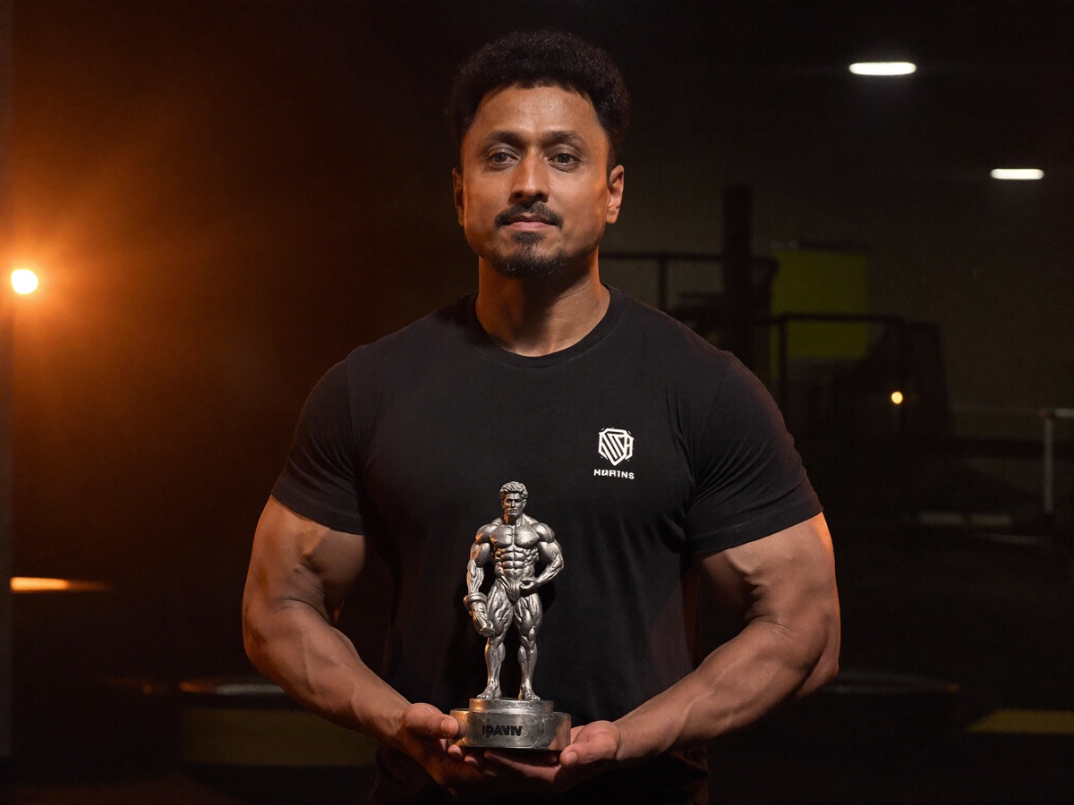Mohsin Sayyed holding a powerlifting championship trophy